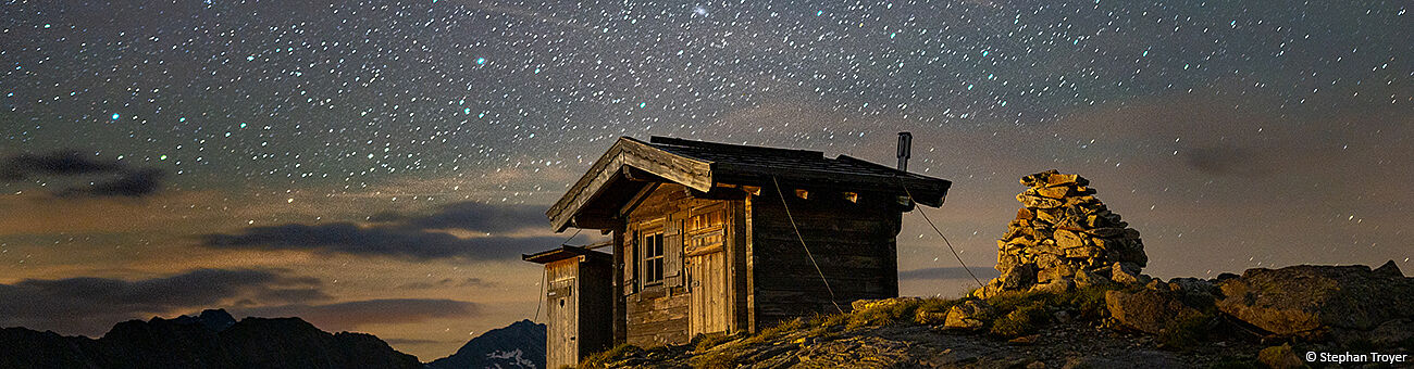 Berghütte vor Sternenhimmel. Foto von Stephan Troyer