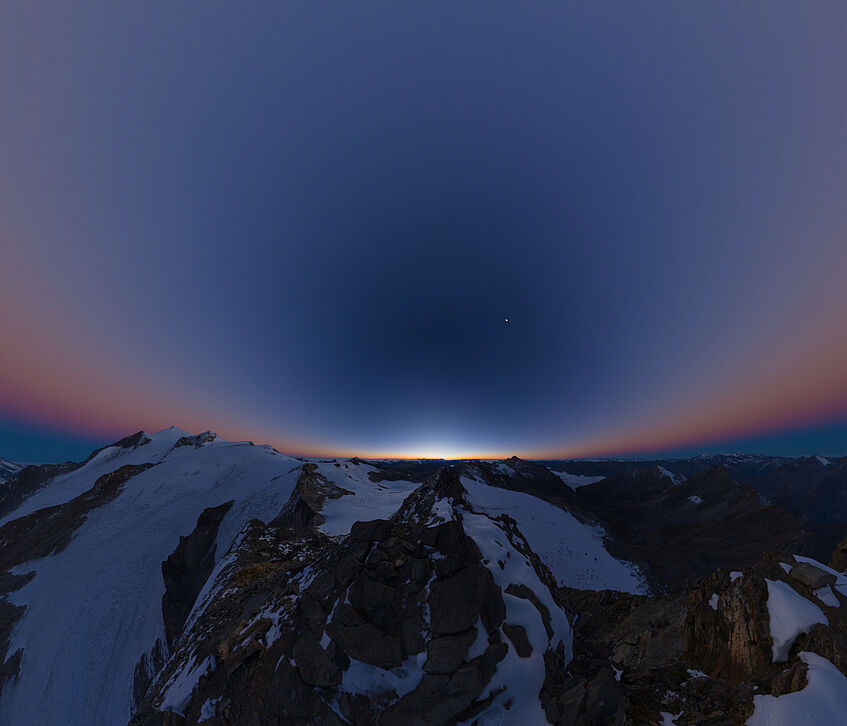 Sonnenaufgang vor Berg, darüber Himmel mit Stern. © Stephan Troyer